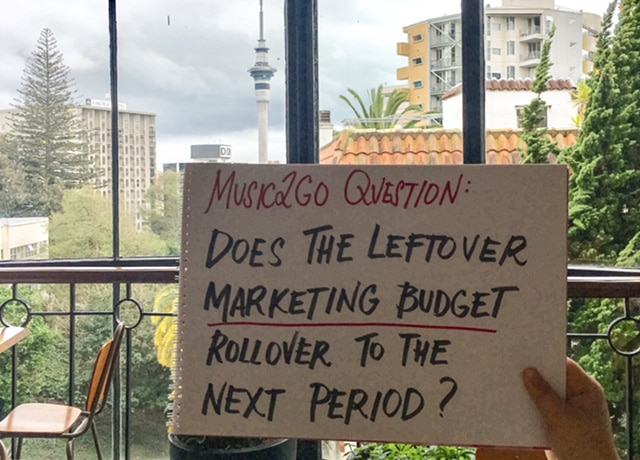 Image of question on piece of paper: "Does the leftover marketing budget rollover to the next period?"